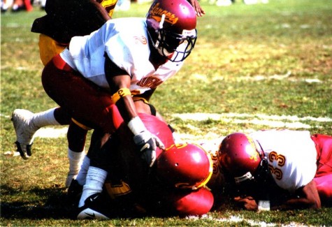 Photo by Roderick DanielsClifford Gatlin, center, gets tackled by PCC defenders Curt Lowther, left, and Olajuan Le Shore.