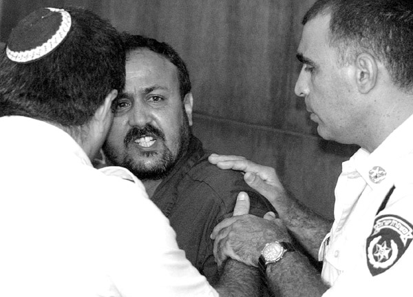 Associated Press
Marwan Barghouti, the West Bank chief of Yasser Arafats Fatah movement, shouts as he is pushed out of the courtroom on the opening day of his court case at Tel Avivs District Court Wednesday. Barghouti, one of the most visible l