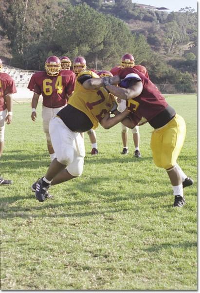 Offensive and defensive linemen take part in an intense drill during practice.