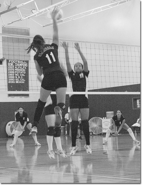 Outside hitter Christie Hyman, No. 11, goes for a kill. The volleyball team is short on wins, but plays with spirit. The young and hard working team is coached by Yvette Ybarra-Cephus.