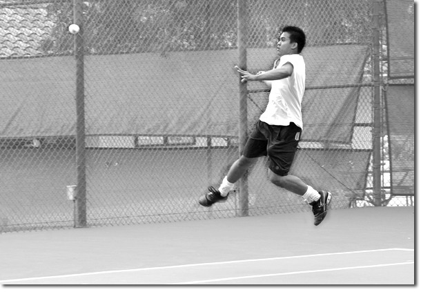 Lew Deleon leaps in the air to deliver a powerful forehand return in a singles win over Allan Hancock College. 