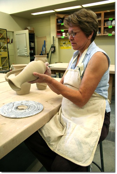 Ceramics student Rose Tharp carves her initials on one of her finished pieces. Tharps work along with the works of other ceramics students will be on sale at the semi-annual ceramic sale happening on Saturday Dec. 2.