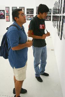 GCC students, Edgar Santacruz, 21, and his brother Hector, 27, view some of professor Ugaldes photography.