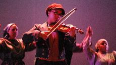 Fiddler Meagon Ligons, bows smoothly throughout the play.