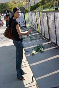 Lusine Bagumyan, 21, nursing student and member of the Armenian Student Association, lays Carnation stems at the foot of New  York Times articles reporting the news of Turkish atrocities against Armenians during the 1915 Genocide.