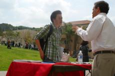 USC Recruitment Coordinator Peter Dean, right, discusses  courses offered with James Baylor, at the Transfer Fair in Plaza Vaquero on April 8.