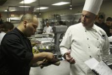 Assistant chef instructor Andrew Feldman consults with culinary arts student Robert Sencion