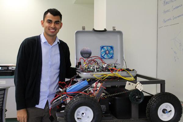 A DAY FOR ENGINEERS: Jose Martinez, above, with the club’s mobile ground vehicle. Armen Toorian,  engineering clinic director, below, looks at the club’s 3D printer. 