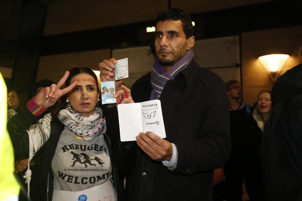 ACTIVISTS: Toktam Johangiry and Salim Azi hold fake passports that read “Nationality: Humanity” at the Jan. 9 protest event.