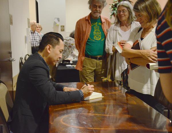 AUTOGRAPHS: Author Viet Thanh Nguyen signs books for fans after a reading in the Adult Recreation Center at the Glendales Central Public Library on Sept. 29.