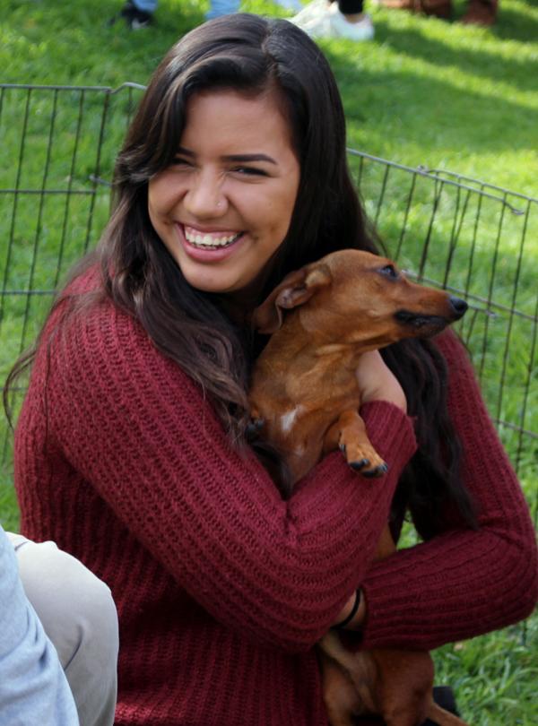 Isabella Alvarez holds tight to one of the two dachshund dogs at ASGCCs Pet and Reset Event on Tuesday in Plaza Vaquero. Students waited in line to play with dogs for one minute, to de-stress during finals week.