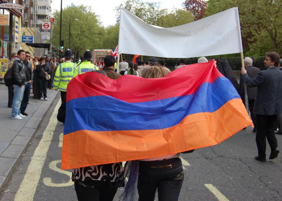 Two+women+holding+an+Armenian+flag+while+participating+in+a+commemorative+march.